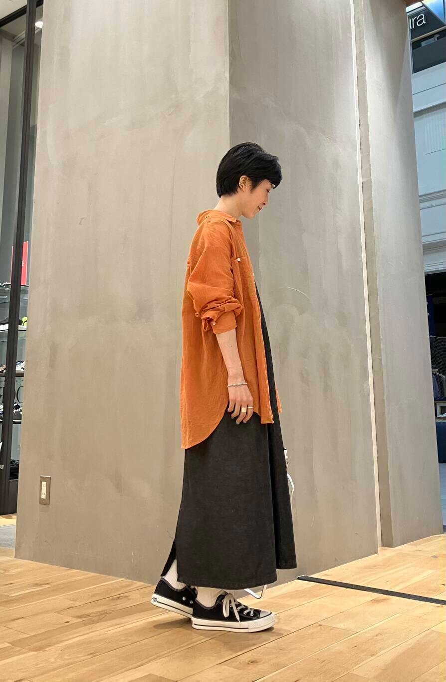 ブラック系のワンピース、ブラック系のスニーカー、ホワイト系のショルダーバッグを着用したレディースの夏コーディネートの3枚目の写真