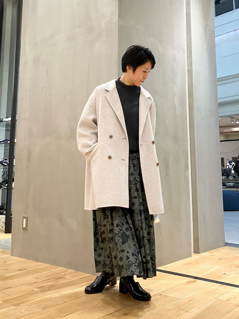 グレー系のニット/セーター、ベージュ系のその他アウター、シルバー系のショルダーバッグを着用したレディースの冬コーディネートの6枚目の写真