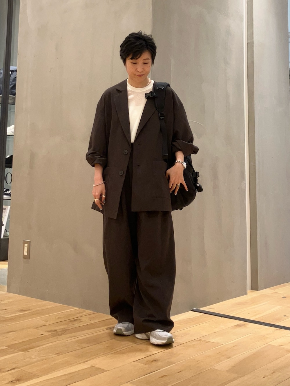 ブラック系のバックパック/リュック、シルバー系のスニーカー、ホワイト系のTシャツ/カットソーを着用したレディースの秋コーディネートの2枚目の写真