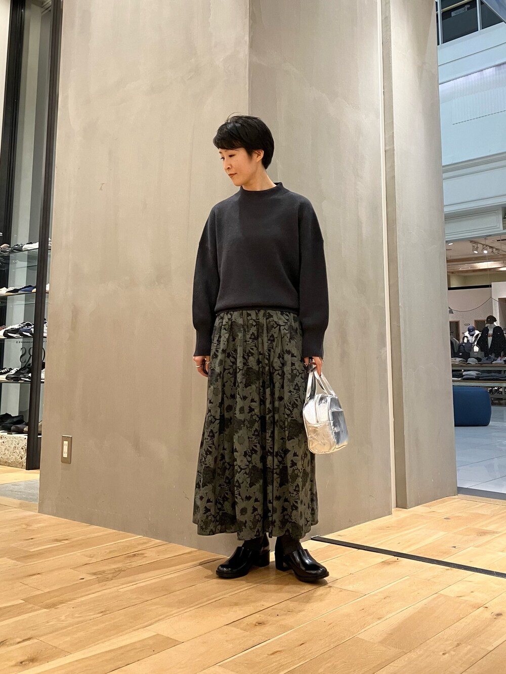 グレー系のニット/セーター、ベージュ系のその他アウター、シルバー系のショルダーバッグを着用したレディースの冬コーディネートの2枚目の写真