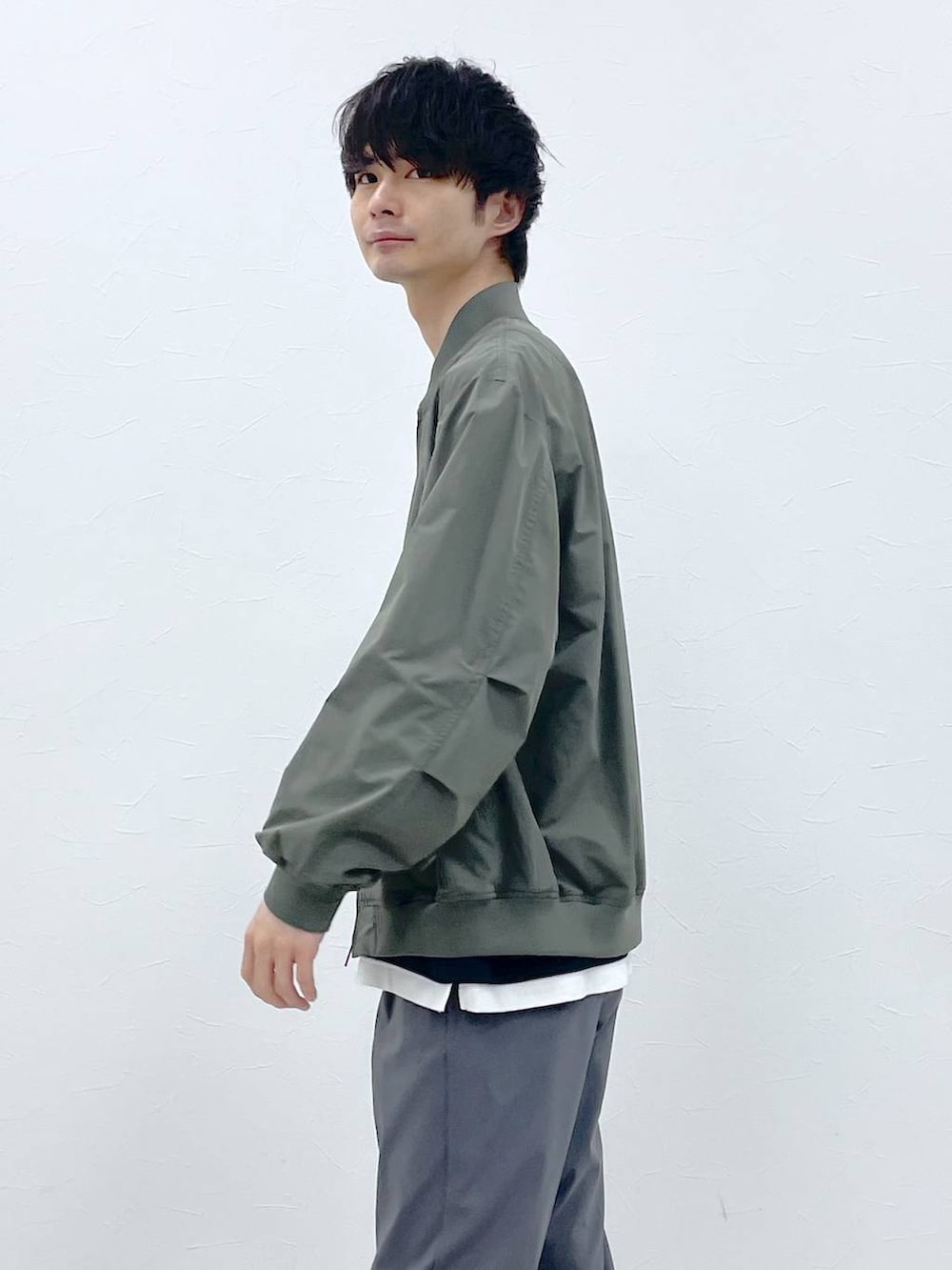 ブラック系のTシャツ/カットソー、グリーン系のMA-1、グレー系のその他パンツを着用したメンズの春コーディネートの2枚目の写真