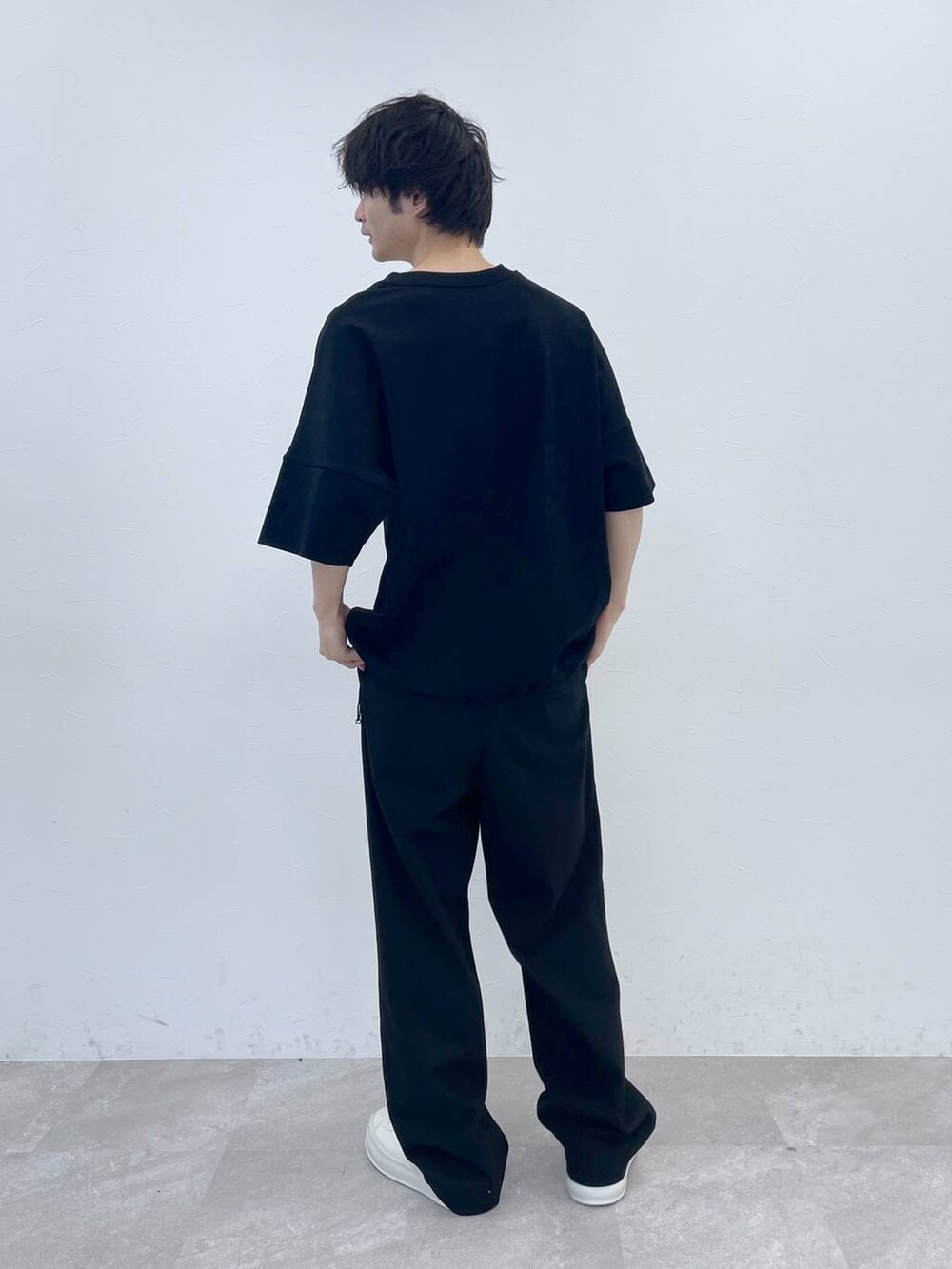 ブラック系のスラックス、ブラック系のTシャツ/カットソーを着用したメンズの冬コーディネートの4枚目の写真