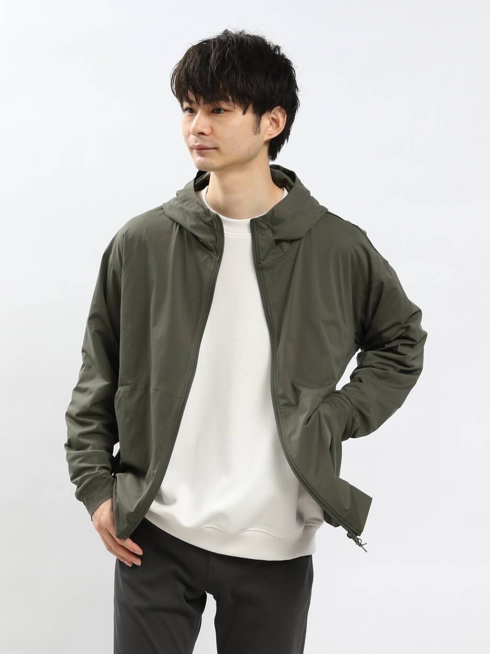 グリーン系のパーカー、グレー系のその他パンツ、ホワイト系のスウェットを着用したメンズの春コーディネートの3枚目の写真