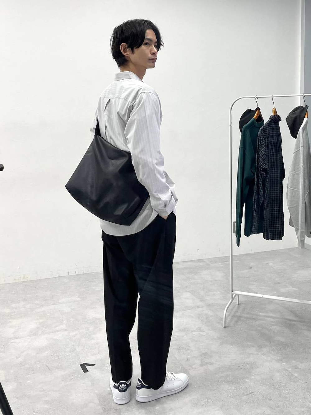 ブラック系のスラックス、ホワイト系のTシャツ/カットソー、ベージュ系のシャツ/ブラウスを着用したメンズの冬コーディネートの2枚目の写真