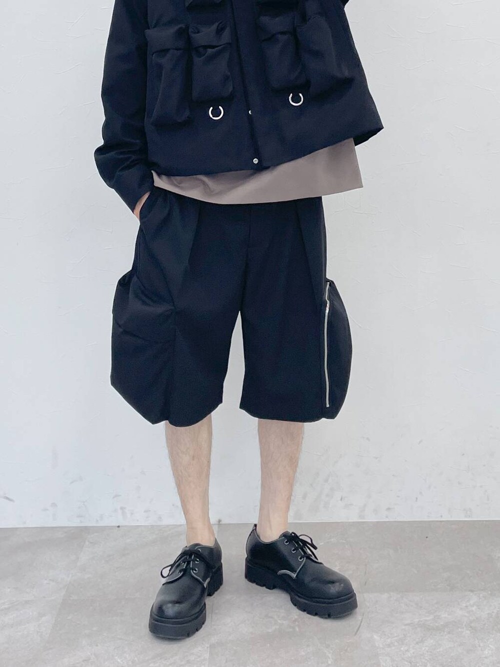 ブラック系のブルゾン、ブラウン系のTシャツ/カットソー、ブラック系のカーゴパンツを着用したメンズの冬コーディネートの5枚目の写真