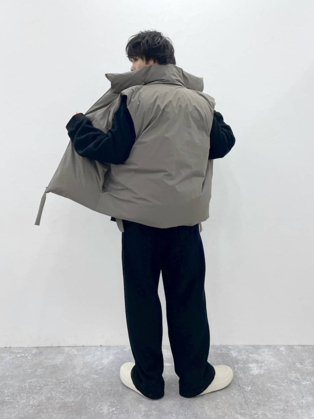 ブラウン系のダウンベスト、グレー系のスウェットパンツ、ブラック系のスウェットを着用したメンズの夏コーディネートの3枚目の写真