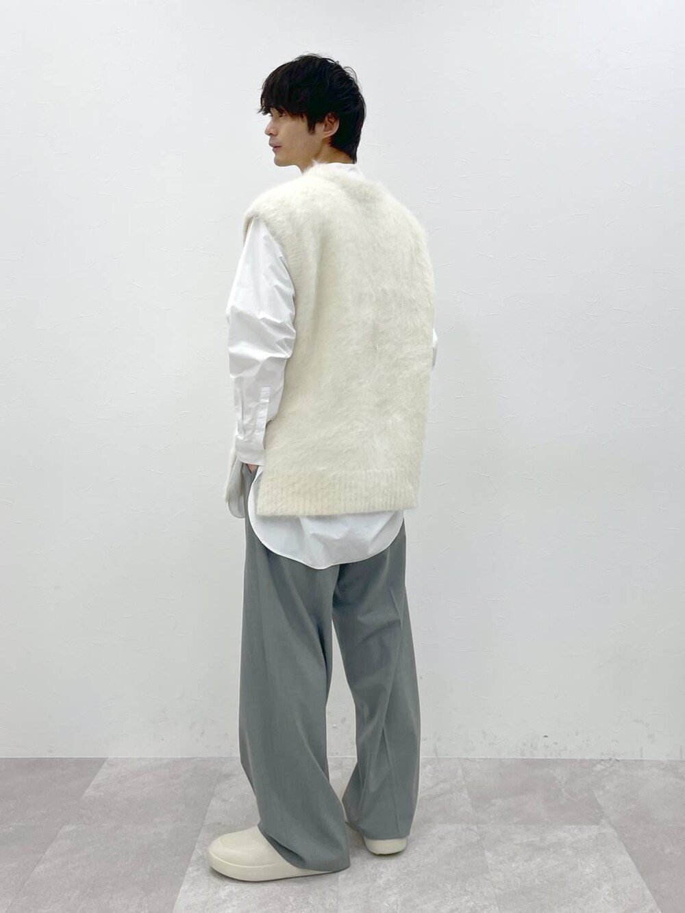 ホワイト系のシャツ/ブラウス、ホワイト系のニット/セーター、グレー系のスラックスを着用したメンズの冬コーディネートの8枚目の写真