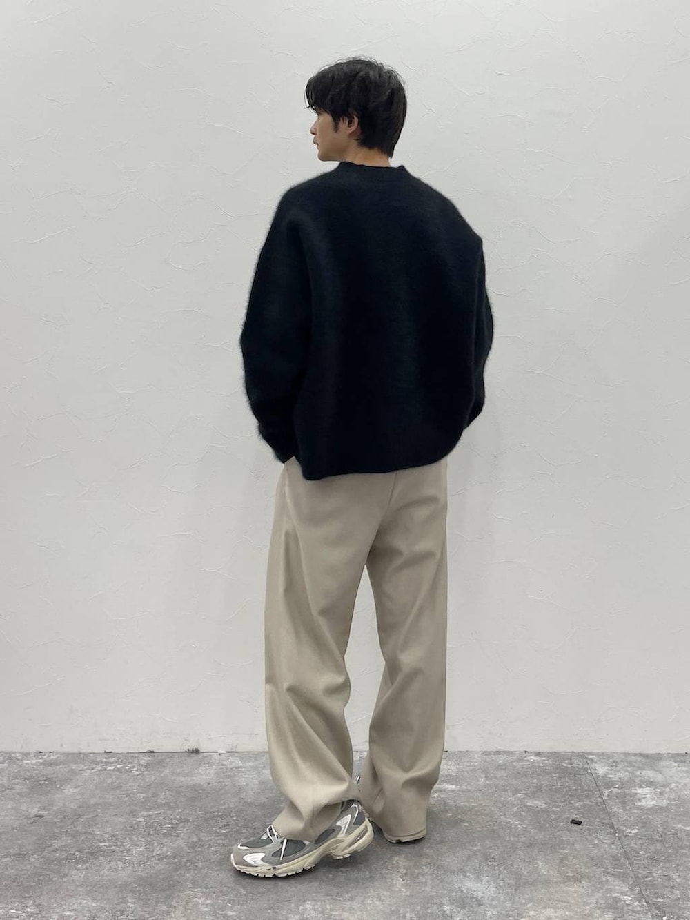ブラック系のダウンジャケット/コート、ベージュ系のその他パンツ、ブラック系のニット/セーターを着用したメンズの秋コーディネートの4枚目の写真