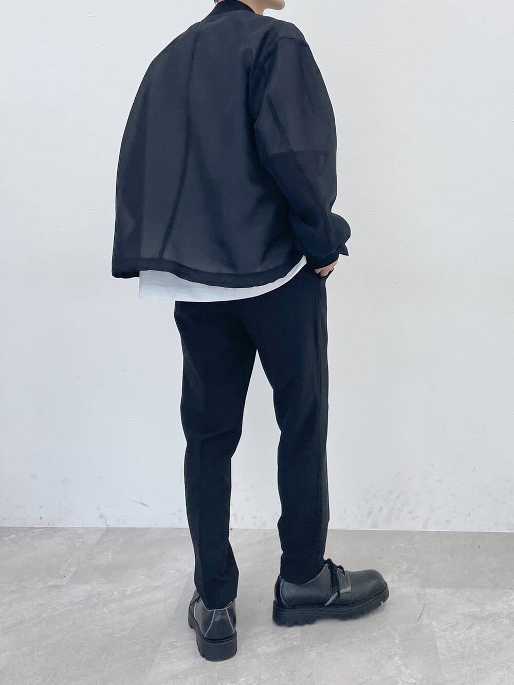 ホワイト系のTシャツ/カットソー、ブラック系のスラックスを着用したメンズの冬コーディネートの3枚目の写真