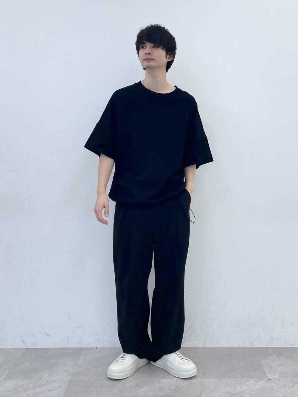 ブラック系のスラックス、ブラック系のTシャツ/カットソーを着用したメンズの冬コーディネートの2枚目の写真