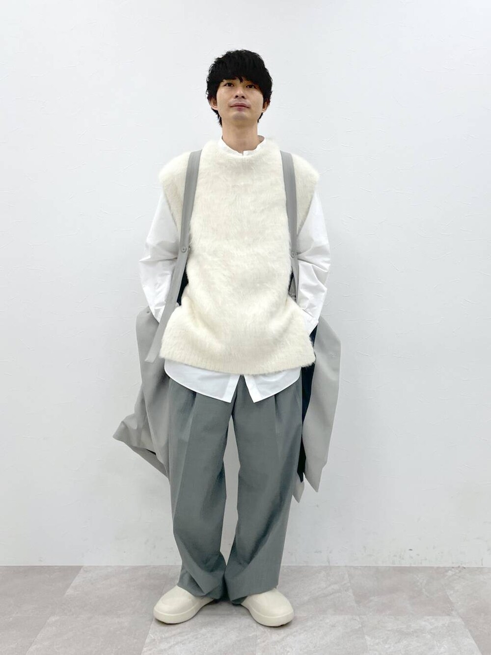 ホワイト系のシャツ/ブラウス、ホワイト系のニット/セーター、グレー系のスラックスを着用したメンズの冬コーディネートの4枚目の写真
