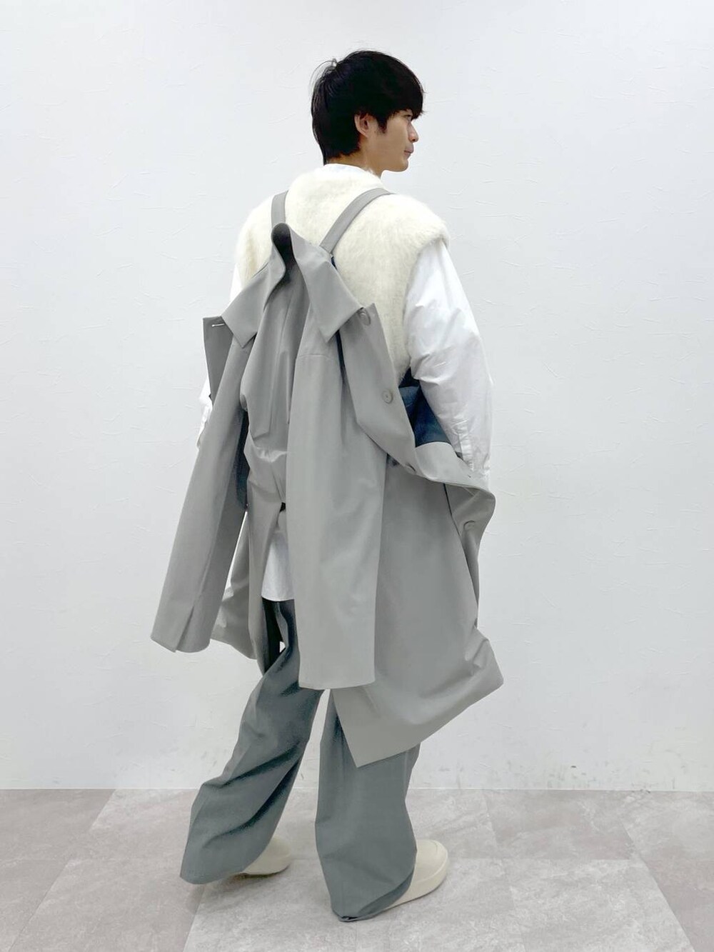 ホワイト系のシャツ/ブラウス、ホワイト系のニット/セーター、グレー系のスラックスを着用したメンズの冬コーディネートの5枚目の写真
