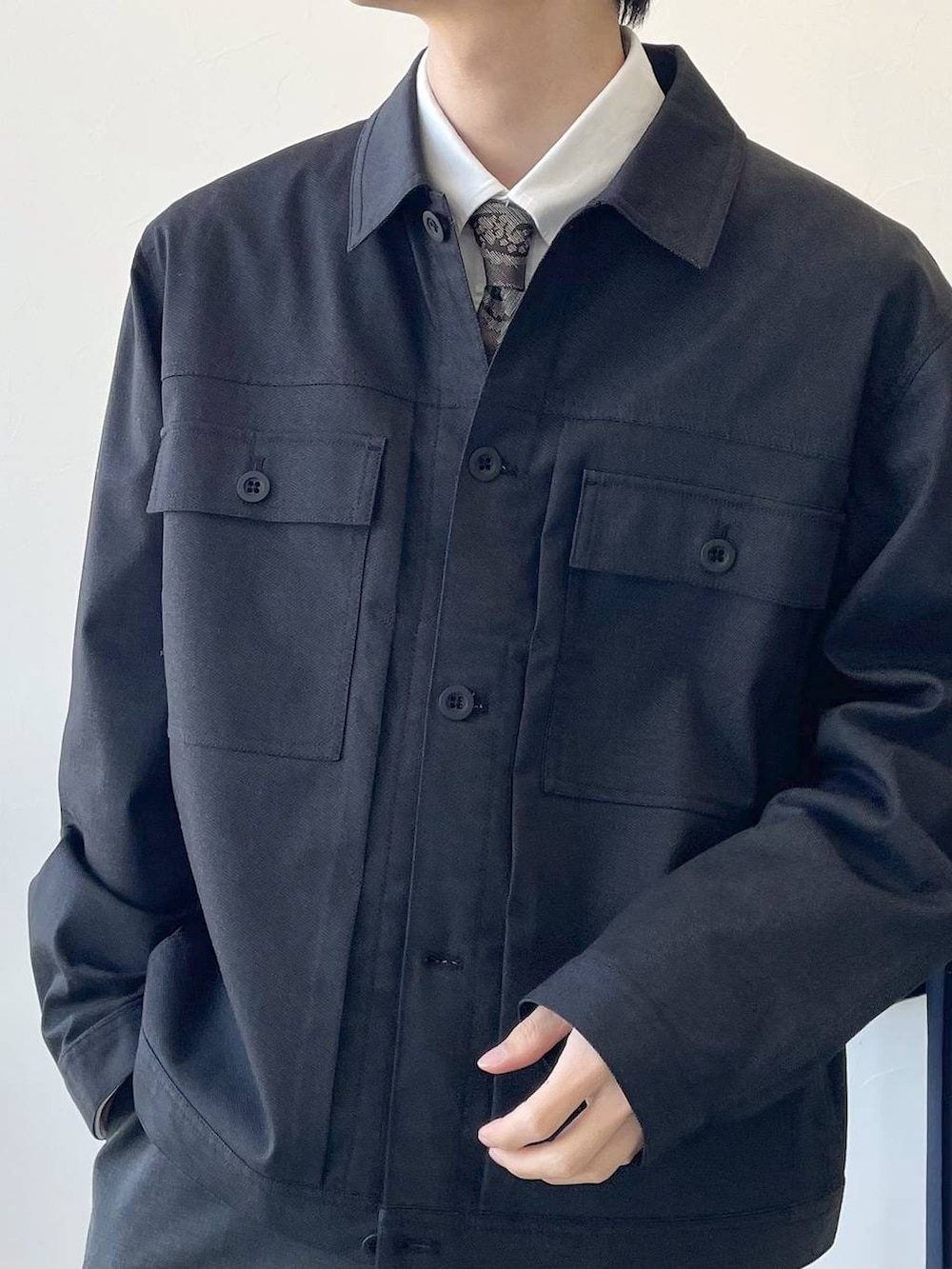 ホワイト系のシャツ/ブラウス、ブラック系のモカシン/デッキシューズ、ブラウン系のネクタイを着用したメンズの冬コーディネートの2枚目の写真