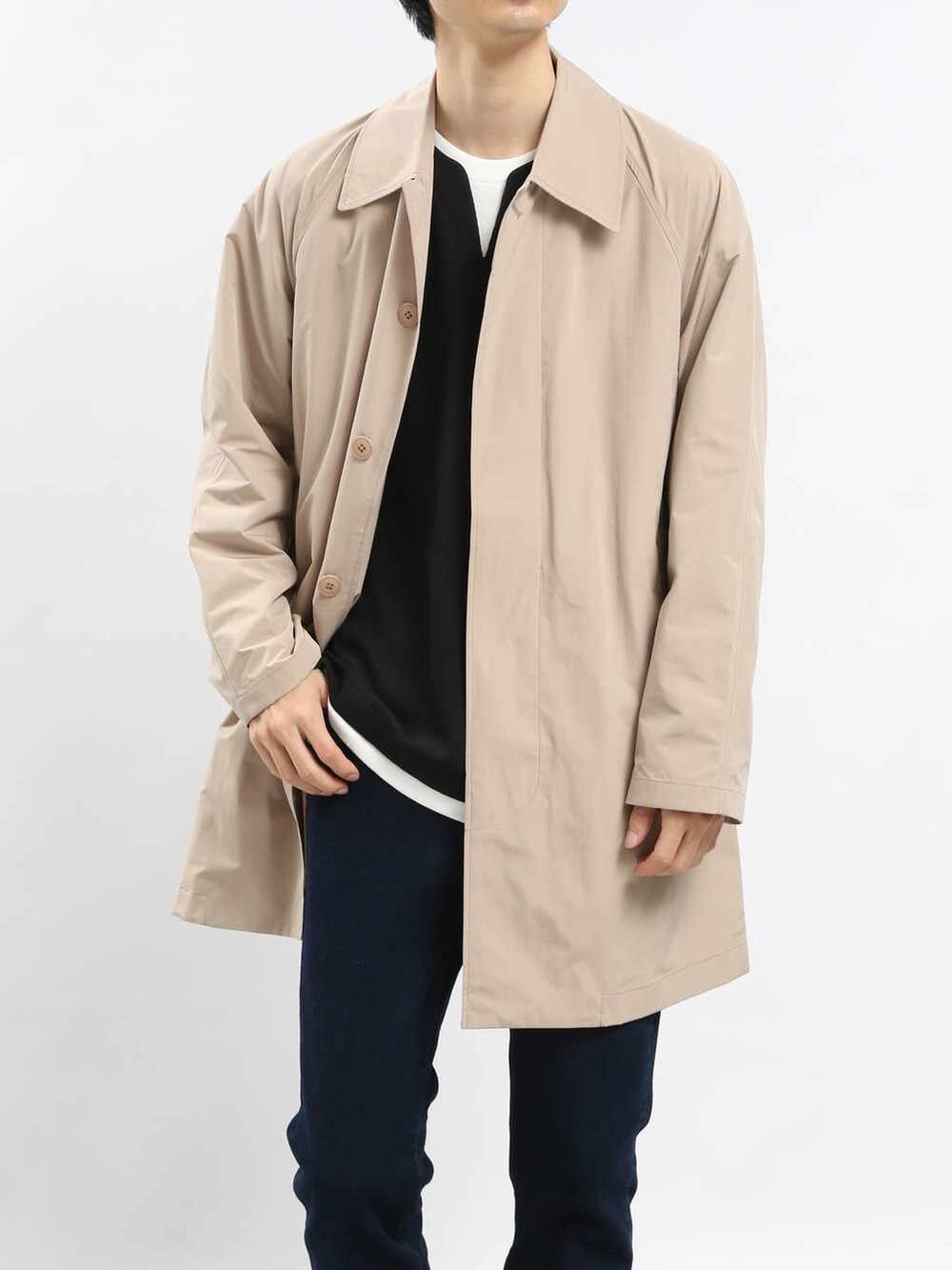 ブルー系のデニムパンツ、ベージュ系のステンカラーコート、ブラック系のTシャツ/カットソーを着用したメンズの冬コーディネートの4枚目の写真