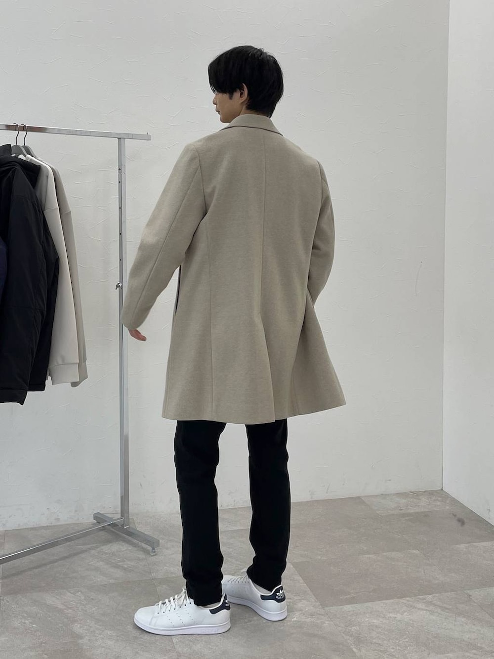 ベージュ系のチェスターコート、グレー系のスウェット、ブラック系のその他パンツを着用したメンズの冬コーディネートの3枚目の写真