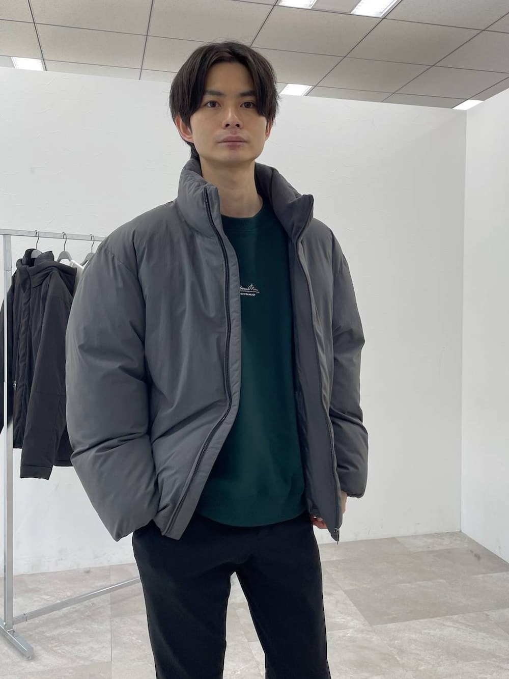 グレー系のブルゾン、グリーン系のスウェット、ブラック系のその他パンツを着用したメンズの冬コーディネートの2枚目の写真