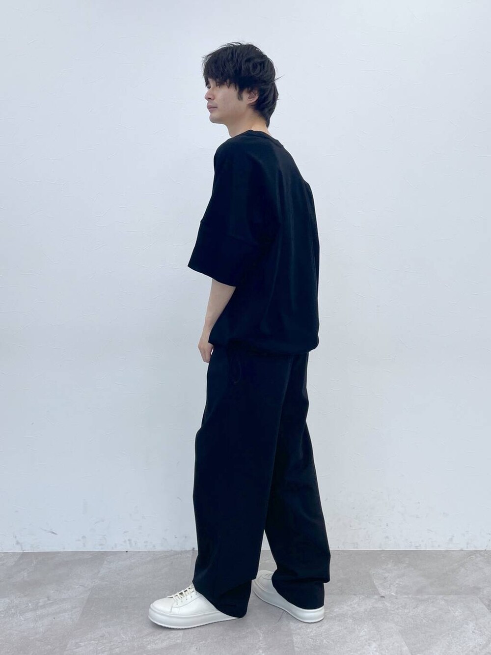 ブラック系のスラックス、ブラック系のTシャツ/カットソーを着用したメンズの冬コーディネートの3枚目の写真