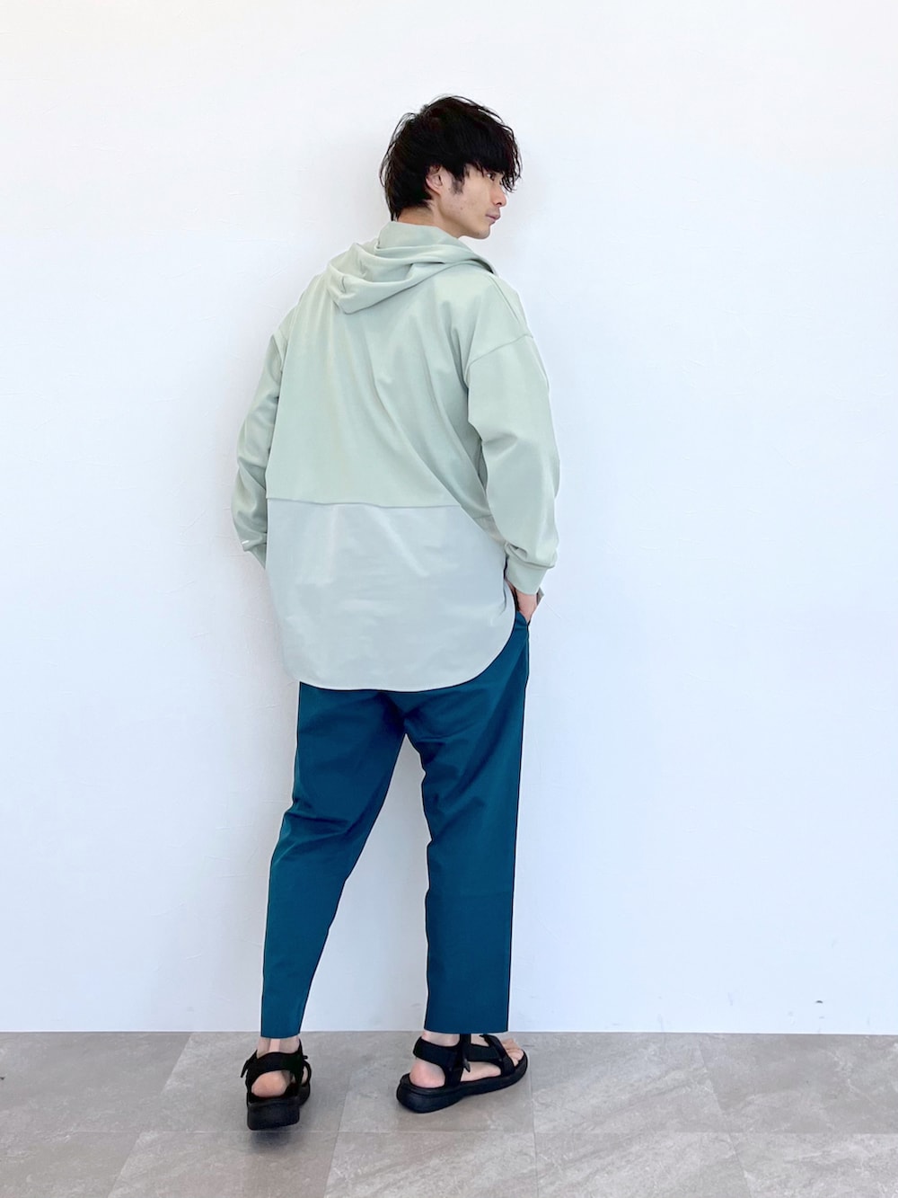 ブラック系のサンダル、ブルー系のその他パンツ、グリーン系のパーカーを着用したメンズの夏コーディネートの3枚目の写真