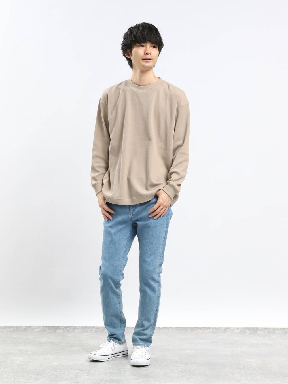 ブルー系のデニムパンツ、ブラック系のパーカー、ベージュ系のTシャツ/カットソーを着用したメンズの春コーディネートの3枚目の写真