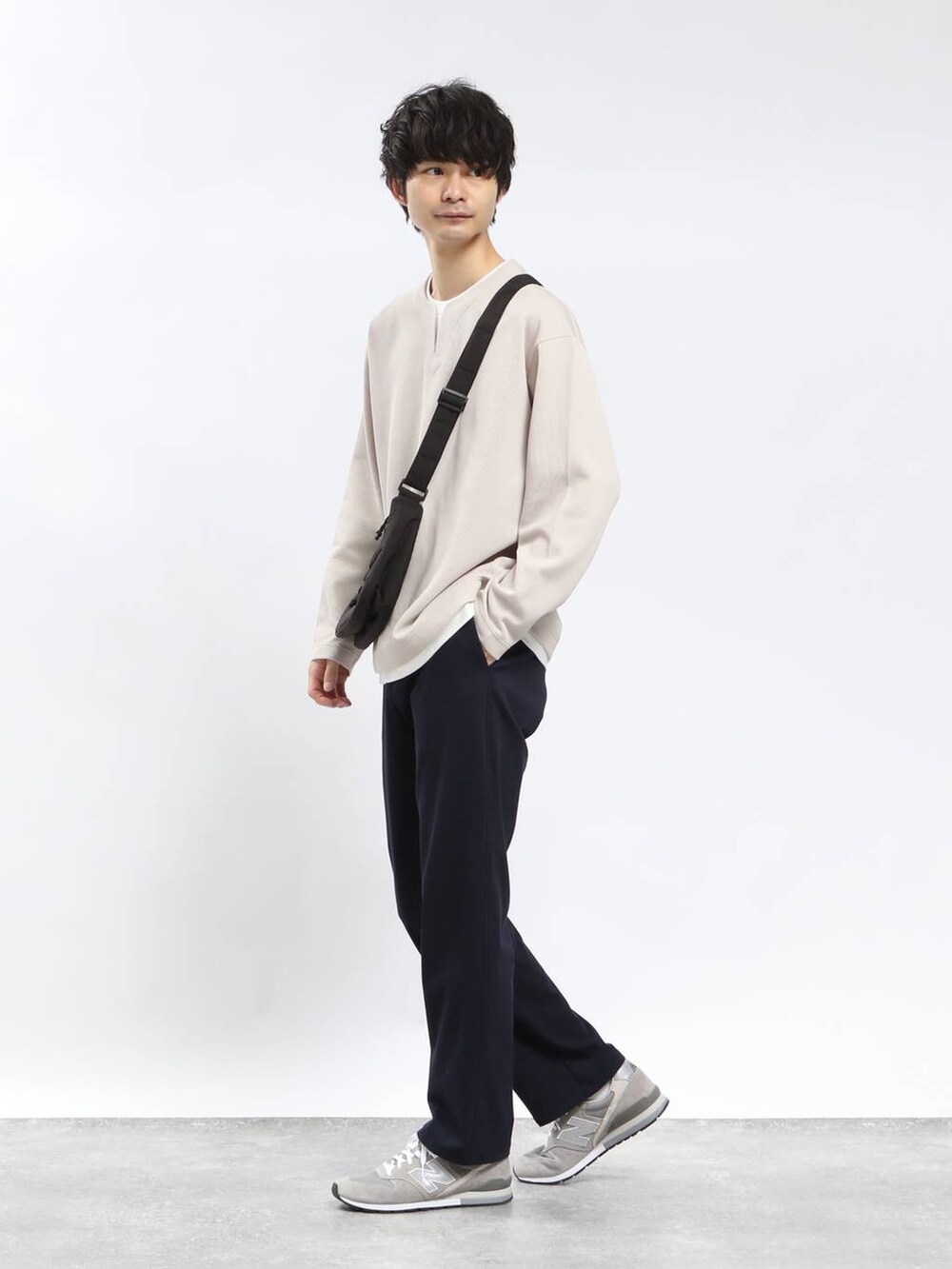 ブルー系のその他パンツ、ブラック系のショルダーバッグ、ベージュ系のTシャツ/カットソーを着用したメンズの春コーディネートの2枚目の写真