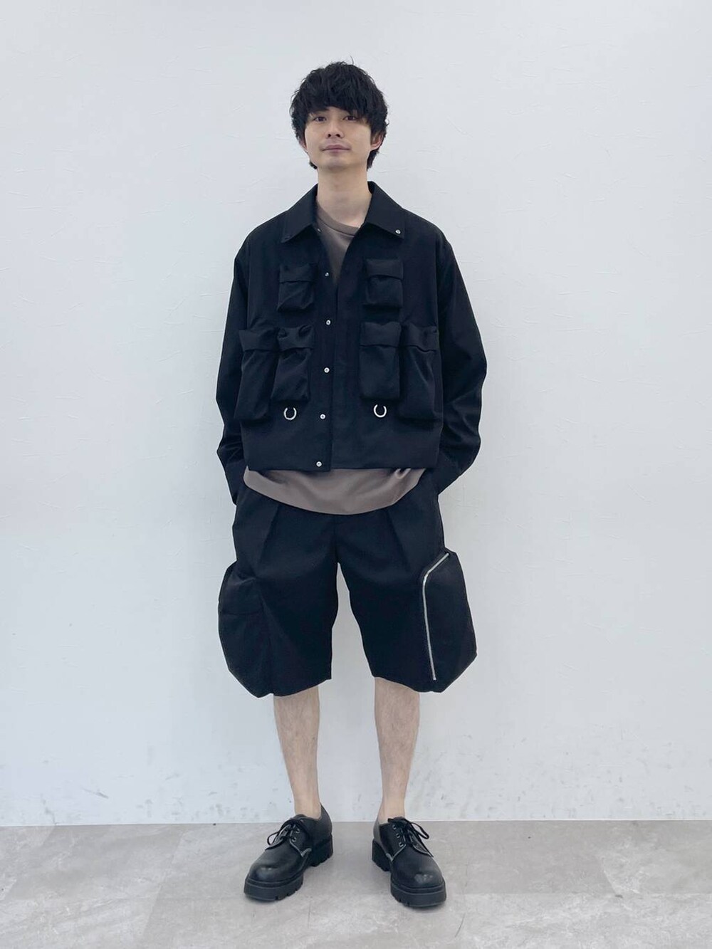 ブラック系のブルゾン、ブラウン系のTシャツ/カットソー、ブラック系のカーゴパンツを着用したメンズの冬コーディネートの3枚目の写真