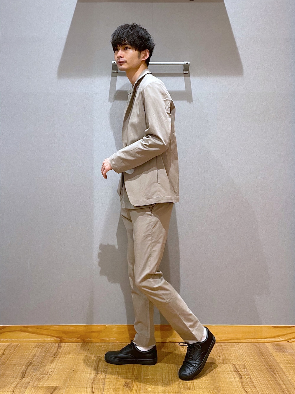 ベージュ系のテーラードジャケット、ベージュ系のその他パンツ、ブラック系のスニーカーを着用したメンズの春コーディネートの2枚目の写真