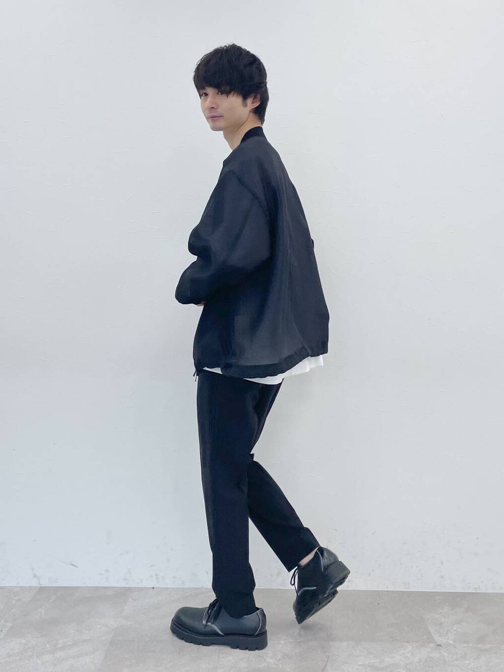 ホワイト系のTシャツ/カットソー、ブラック系のスラックスを着用したメンズの冬コーディネートの2枚目の写真