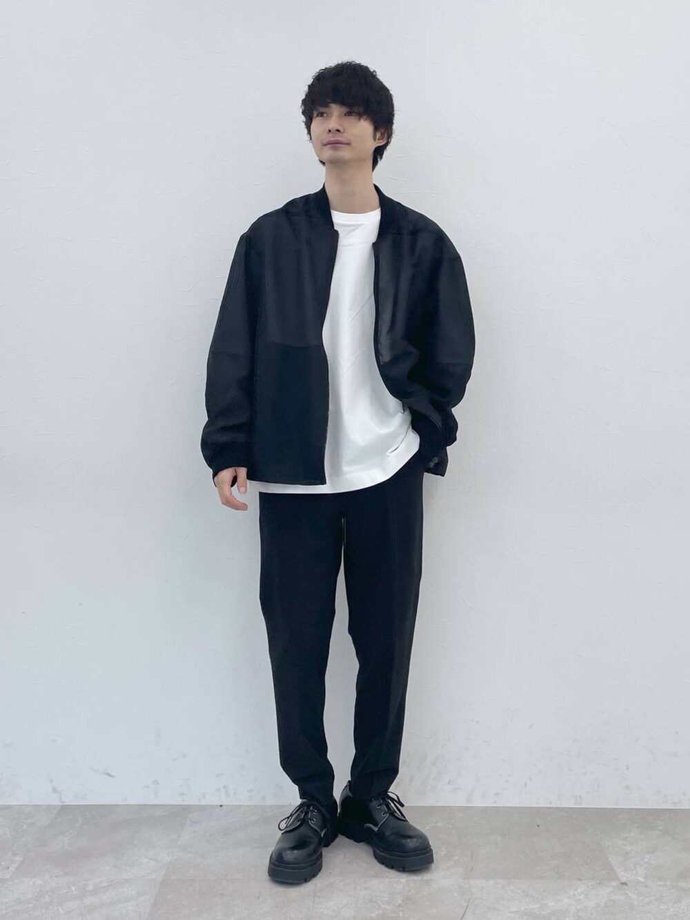 ホワイト系のTシャツ/カットソー、ブラック系のスラックスを着用したメンズの冬コーディネートの4枚目の写真