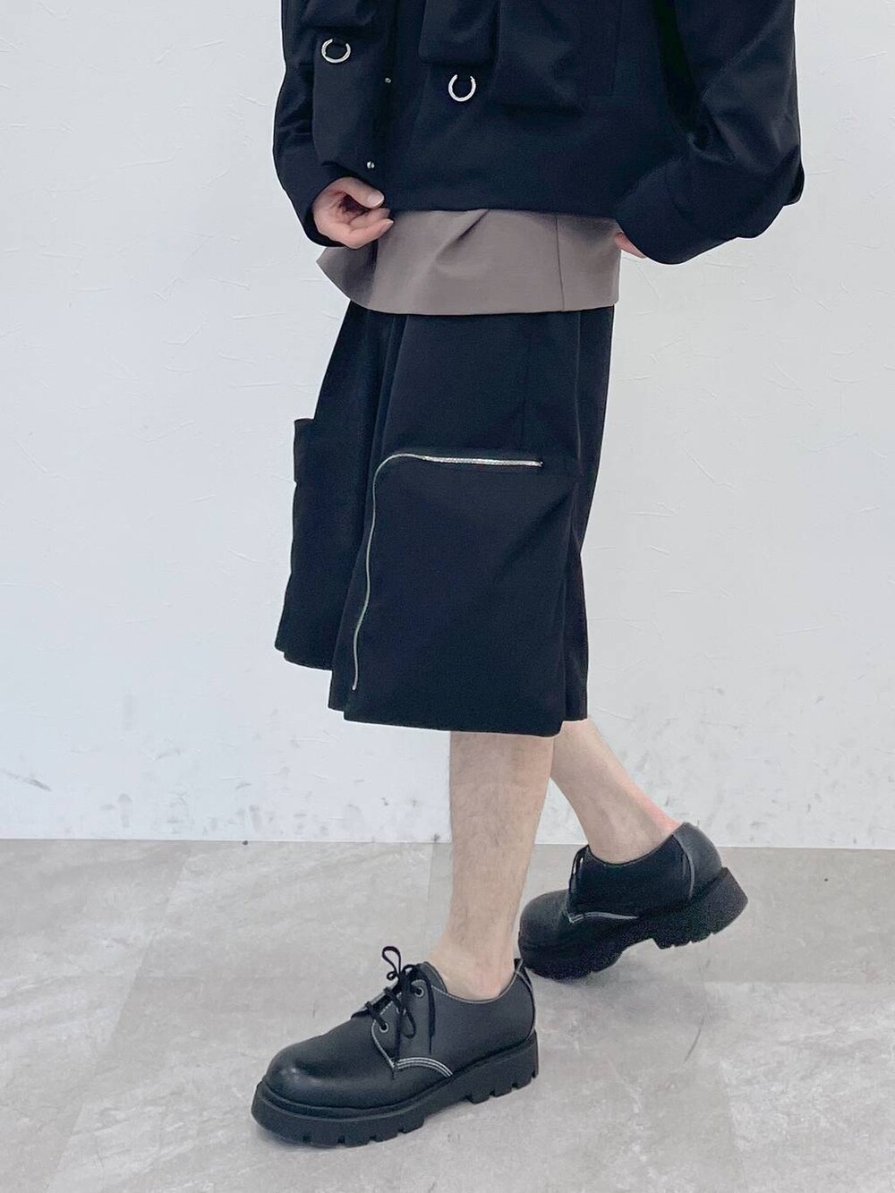 ブラック系のブルゾン、ブラウン系のTシャツ/カットソー、ブラック系のカーゴパンツを着用したメンズの冬コーディネートの4枚目の写真