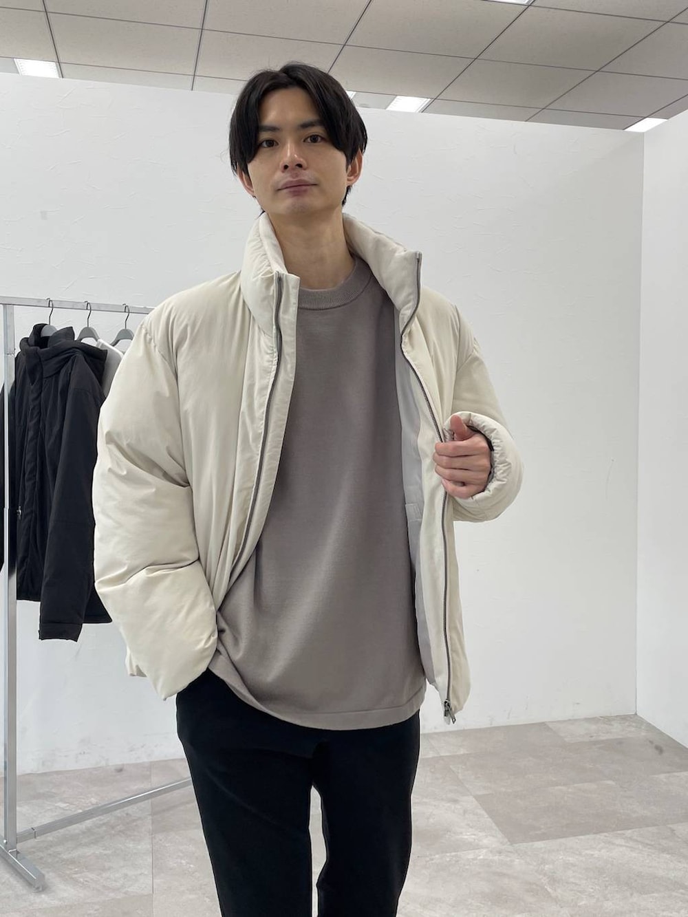 ホワイト系のブルゾン、ベージュ系のニット/セーター、ブラック系のその他パンツを着用したメンズの冬コーディネートの3枚目の写真