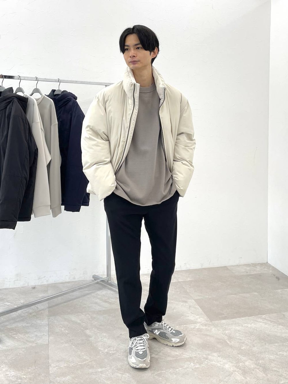 ホワイト系のブルゾン、ベージュ系のニット/セーター、ブラック系のその他パンツを着用したメンズの冬コーディネートの2枚目の写真