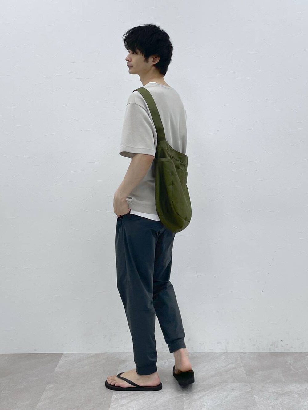 グリーン系のショルダーバッグ、ベージュ系のTシャツ/カットソーを着用したメンズの春コーディネートの2枚目の写真