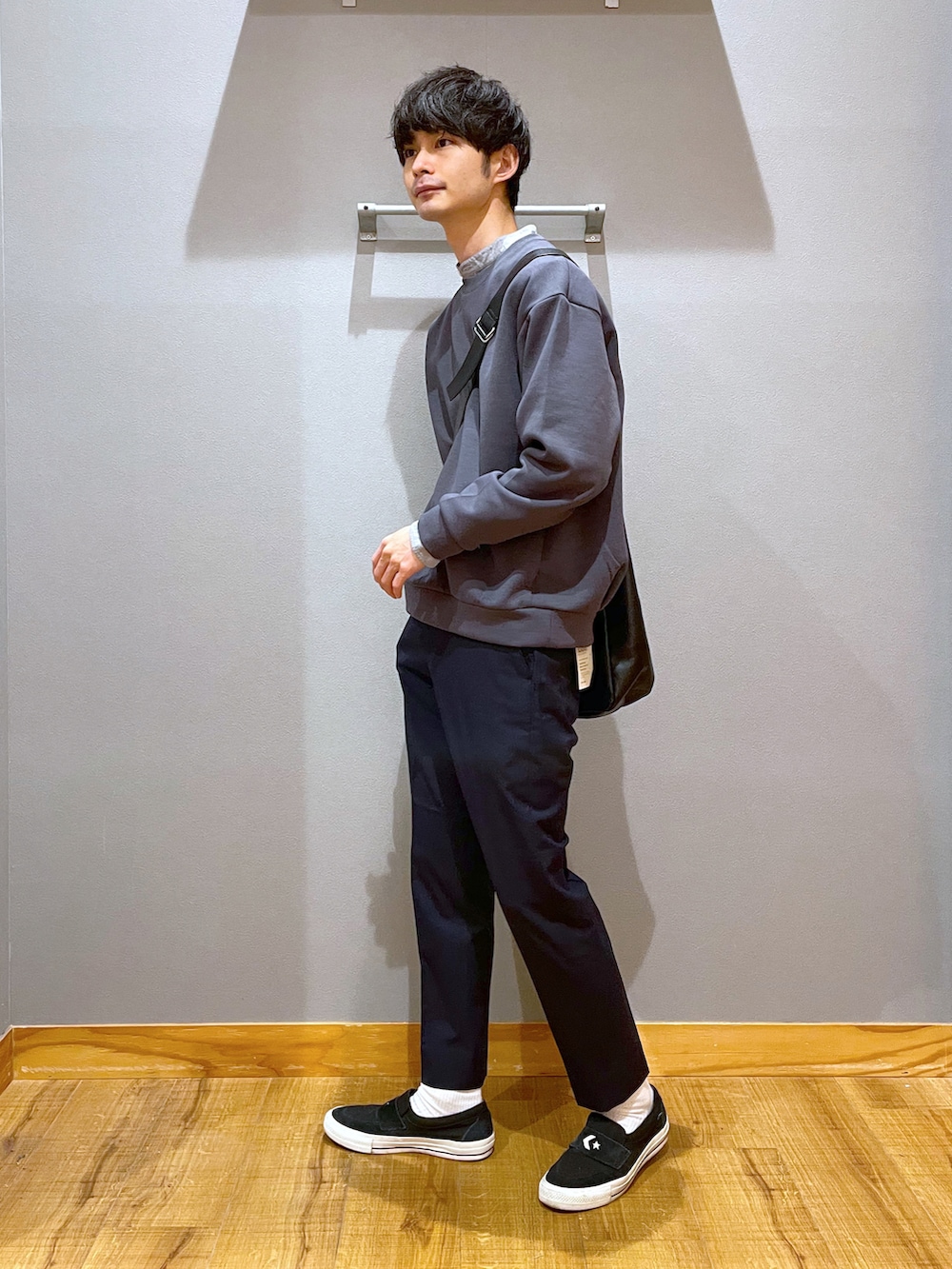 ブルー系のスラックス、グレー系のショルダーバッグ、グレー系のスウェットを着用したメンズの春コーディネートの2枚目の写真