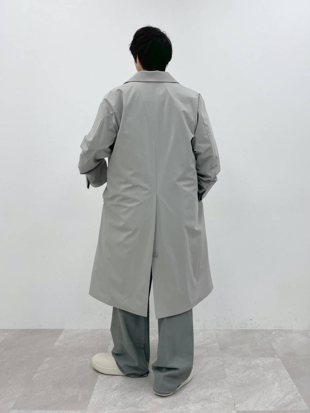 ホワイト系のシャツ/ブラウス、ホワイト系のニット/セーター、グレー系のスラックスを着用したメンズの冬コーディネートの3枚目の写真