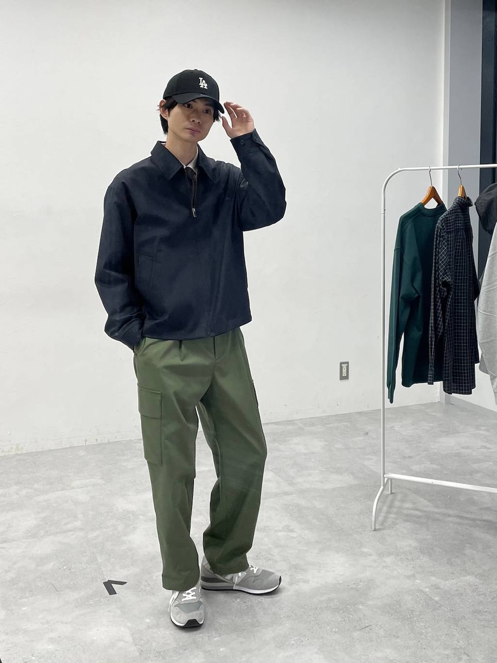 グリーン系のカーゴパンツ、ベージュ系のシャツ/ブラウス、ブラック系のキャップを着用したメンズの冬コーディネートの2枚目の写真