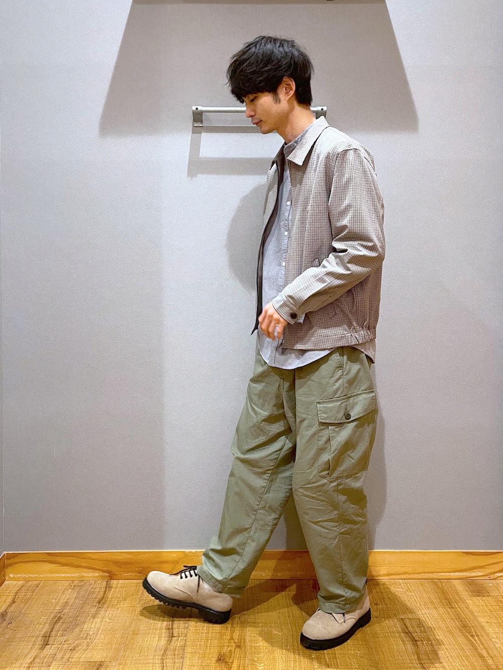 グリーン系のデニムパンツ、ベージュ系のドレスシューズ、ブラウン系のブルゾンを着用したメンズの春コーディネートの2枚目の写真