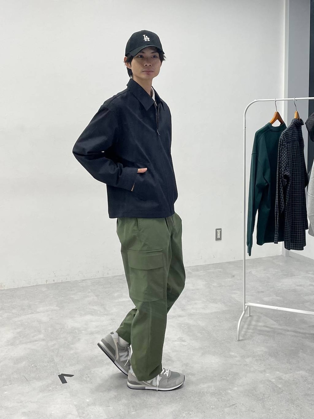 グリーン系のカーゴパンツ、ベージュ系のシャツ/ブラウス、ブラック系のキャップを着用したメンズの冬コーディネートの3枚目の写真