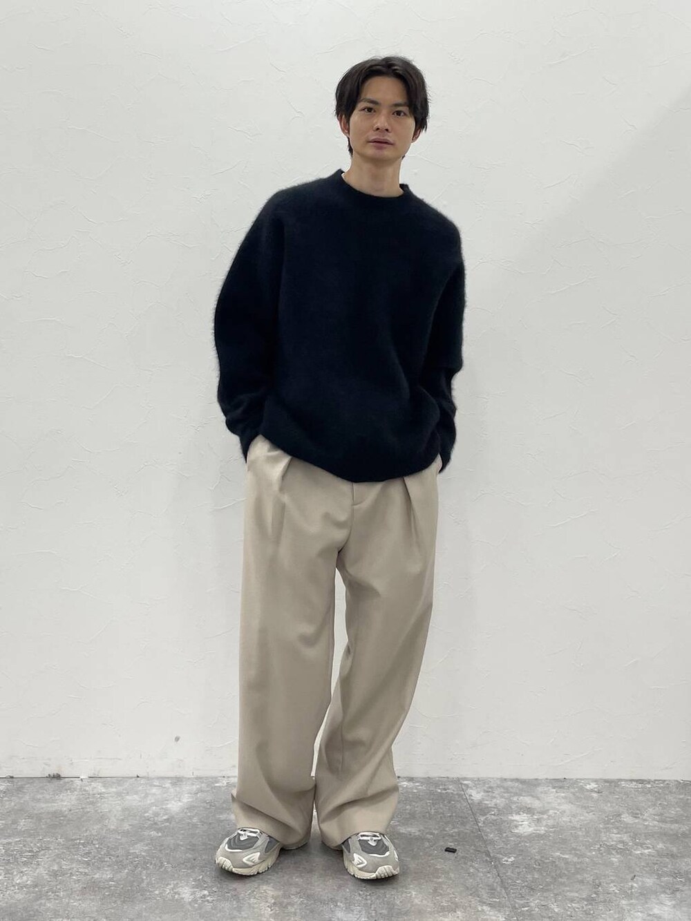 ブラック系のダウンジャケット/コート、ベージュ系のその他パンツ、ブラック系のニット/セーターを着用したメンズの秋コーディネートの3枚目の写真