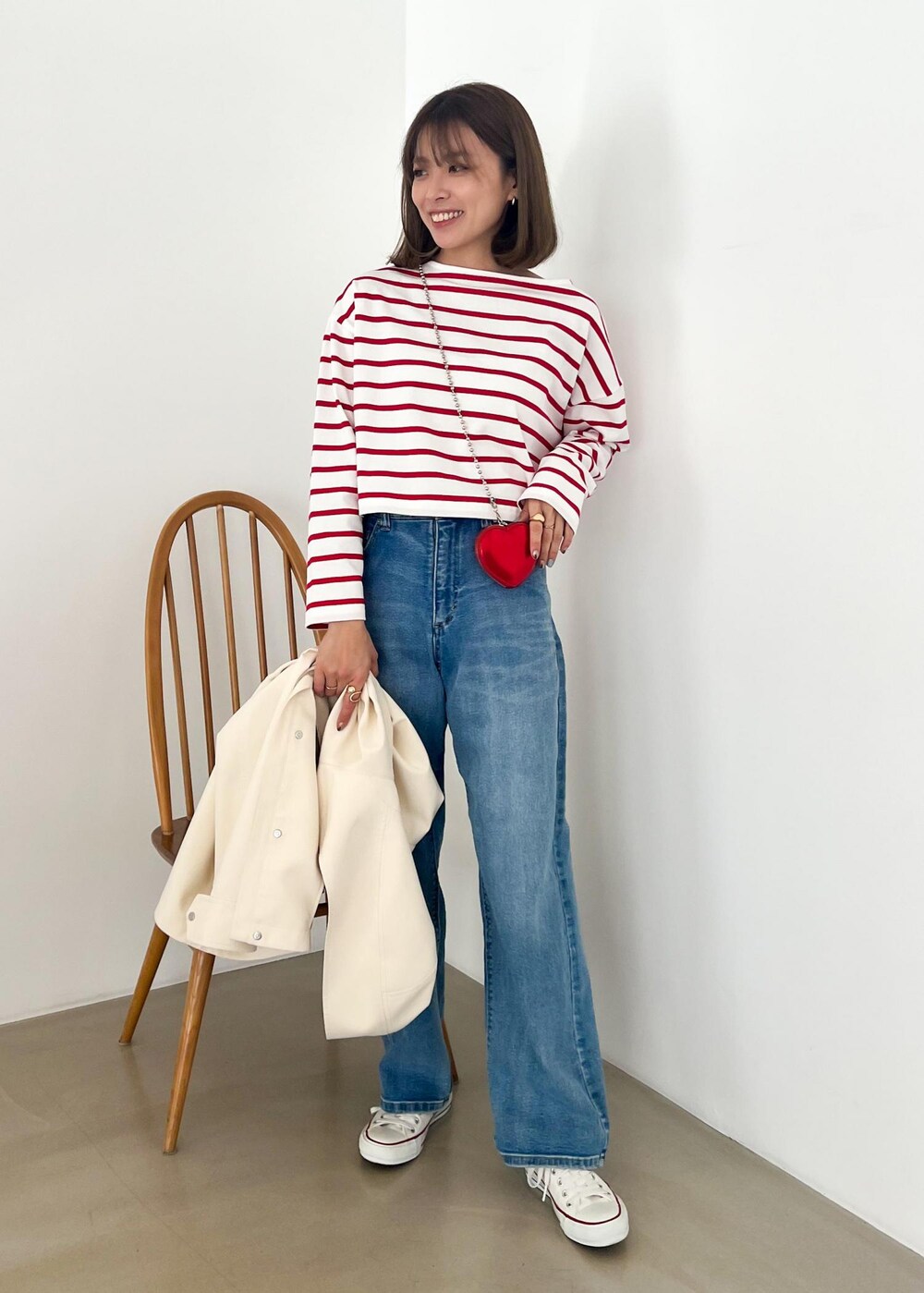 ホワイト系のマウンテンパーカー、レッド系のTシャツ/カットソー、ブルー系のデニムパンツを着用したレディースの冬コーディネートの4枚目の写真