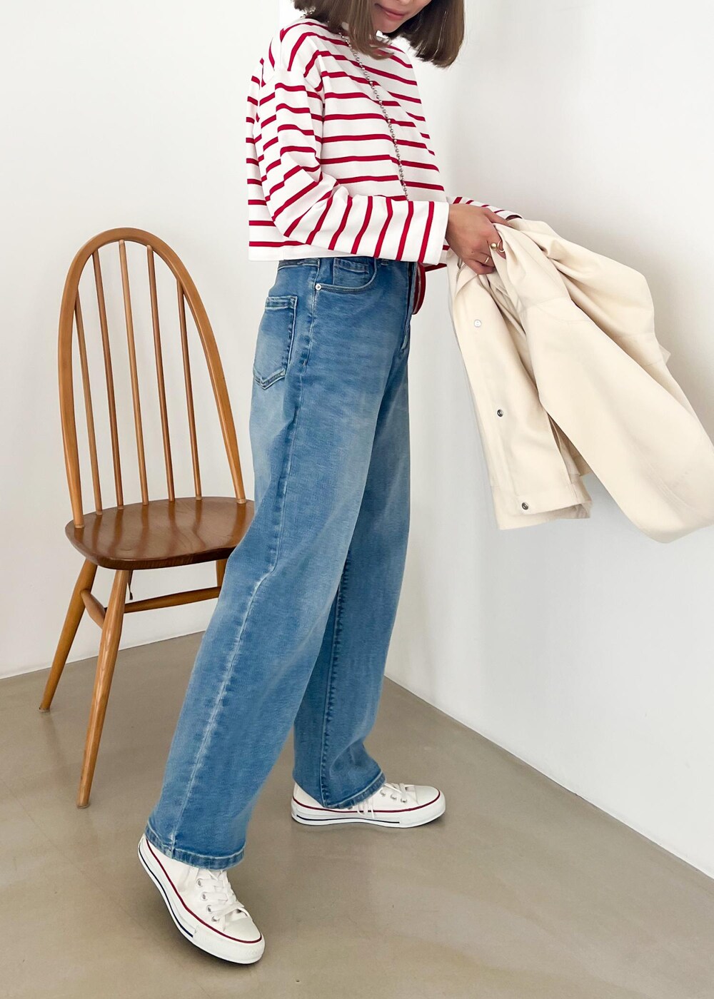 ホワイト系のマウンテンパーカー、レッド系のTシャツ/カットソー、ブルー系のデニムパンツを着用したレディースの冬コーディネートの5枚目の写真
