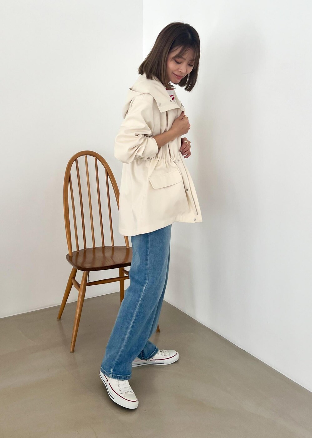 ホワイト系のマウンテンパーカー、レッド系のTシャツ/カットソー、ブルー系のデニムパンツを着用したレディースの冬コーディネートの2枚目の写真