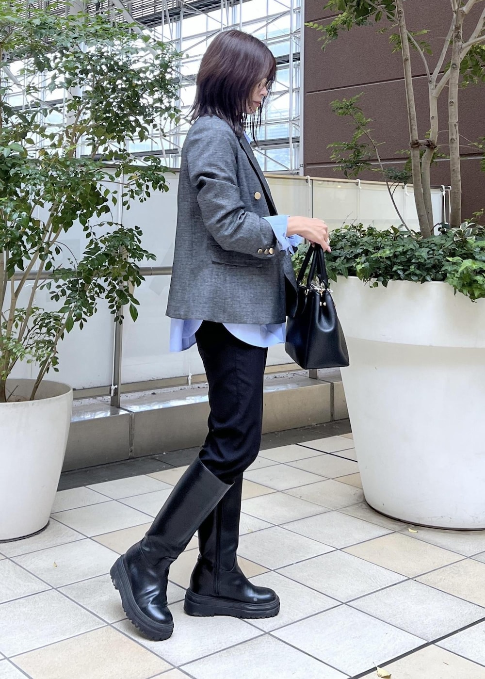 ブラック系のその他パンツ、ブラック系のショルダーバッグ、ブルー系のシャツ/ブラウスを着用したレディースの冬コーディネートの4枚目の写真