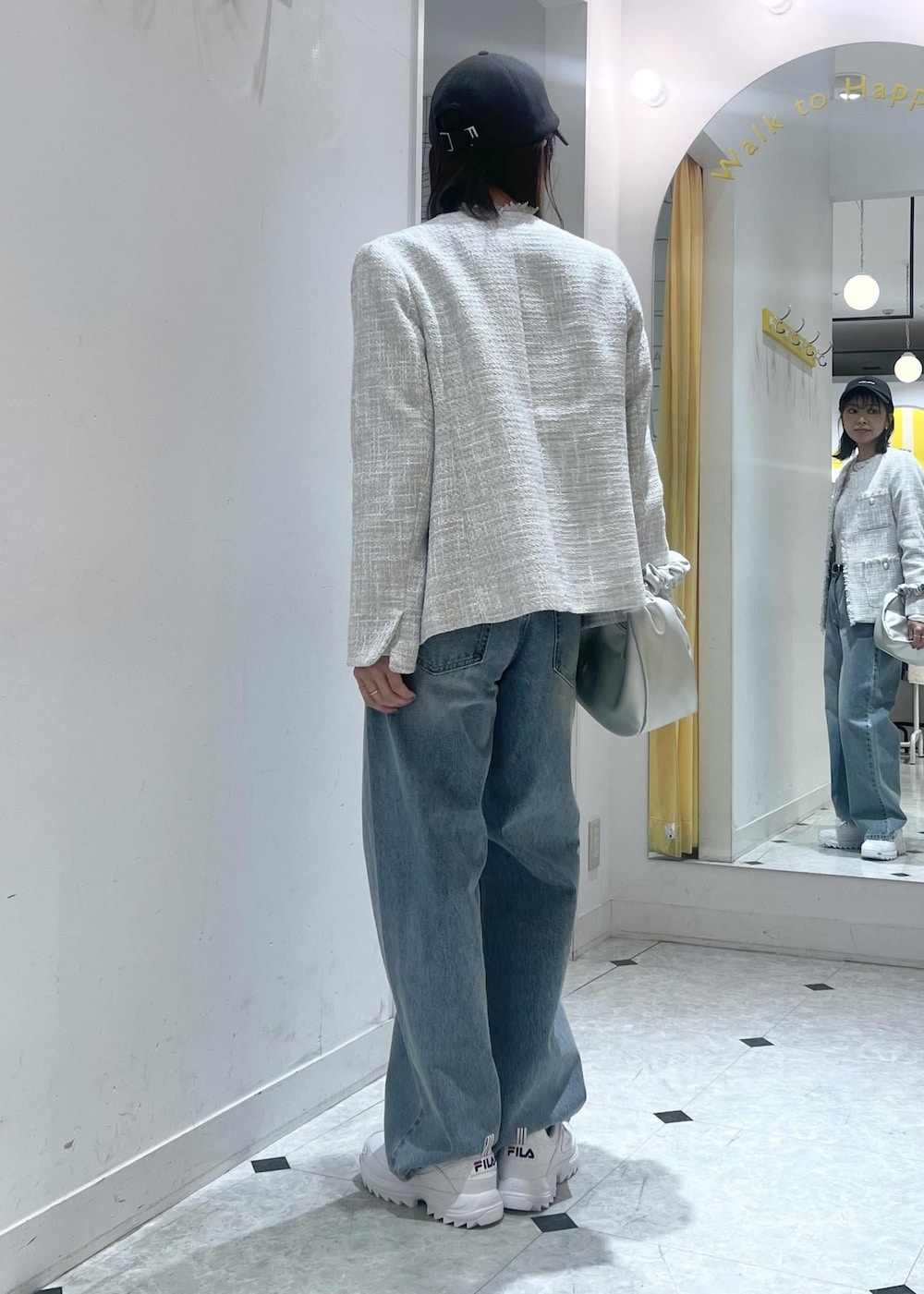 ホワイト系のTシャツ/カットソー、シルバー系のハンドバッグ、グレー系のノーカラージャケットを着用したレディースの冬コーディネートの5枚目の写真