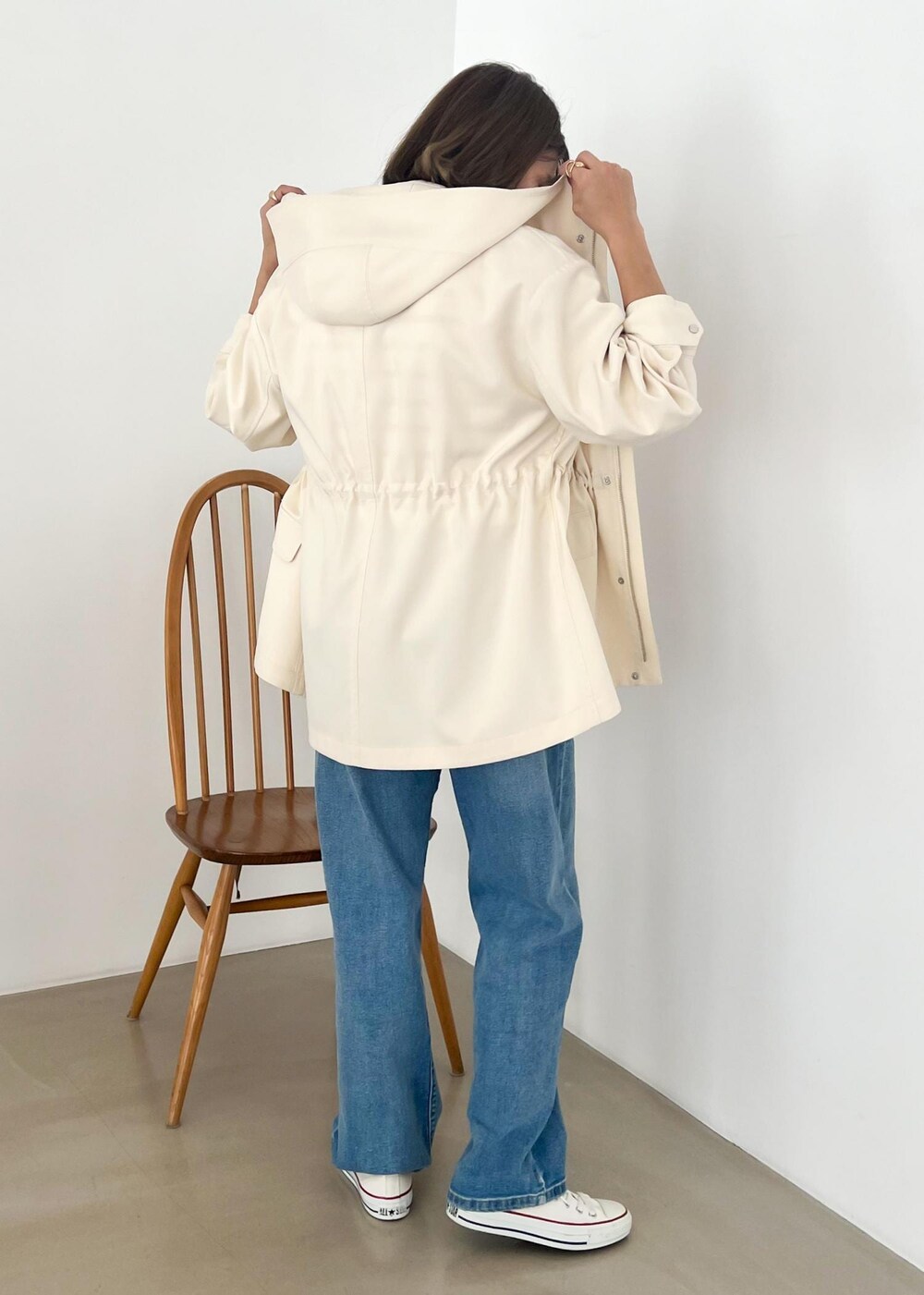 ホワイト系のマウンテンパーカー、レッド系のTシャツ/カットソー、ブルー系のデニムパンツを着用したレディースの冬コーディネートの3枚目の写真