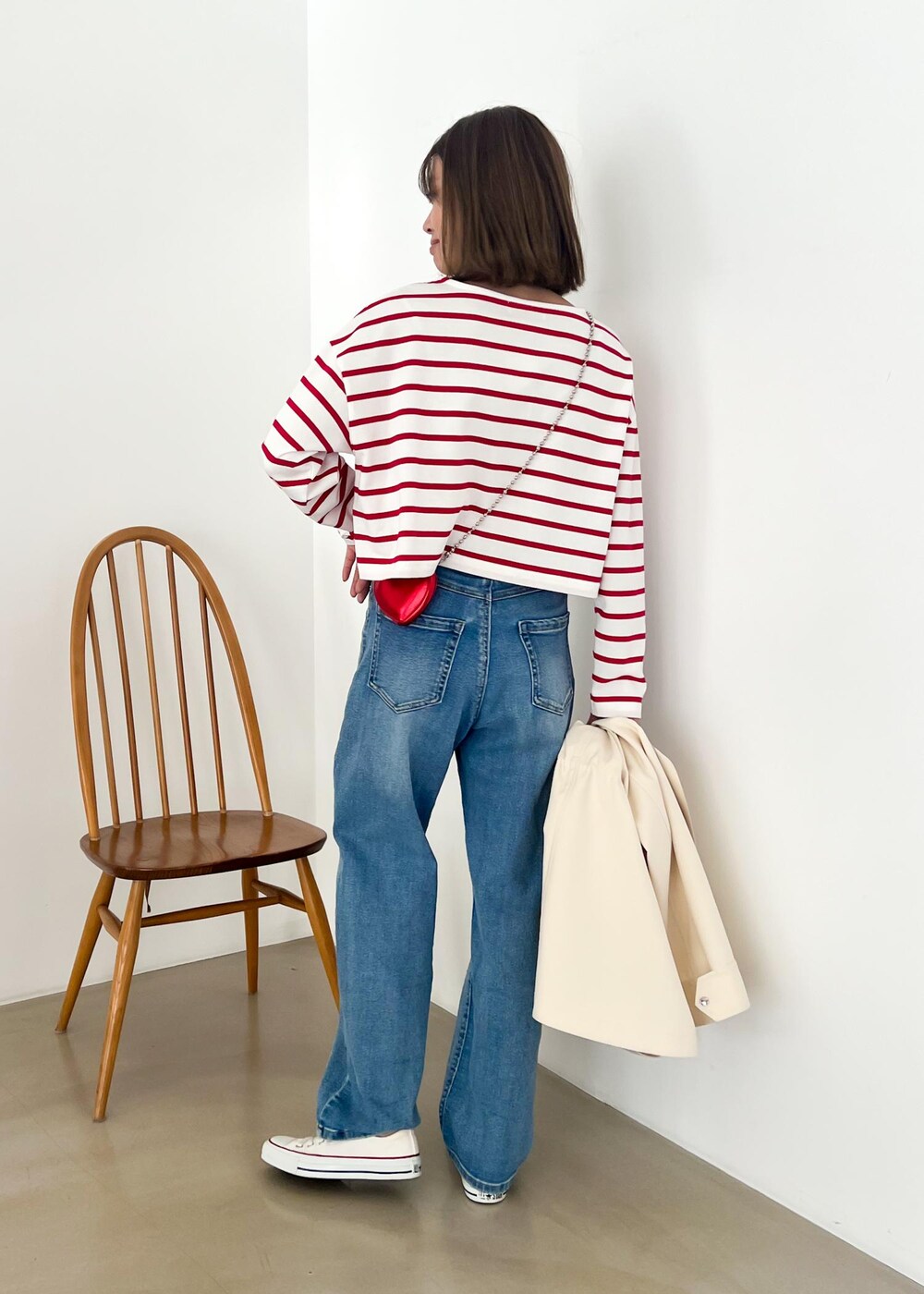 ホワイト系のマウンテンパーカー、レッド系のTシャツ/カットソー、ブルー系のデニムパンツを着用したレディースの冬コーディネートの6枚目の写真