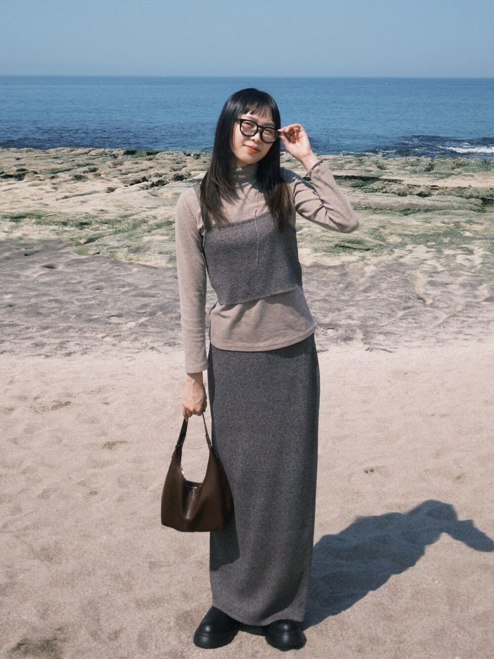 ブルー系のスカート、シルバー系のネックレスを着用したレディースの春コーディネートの2枚目の写真