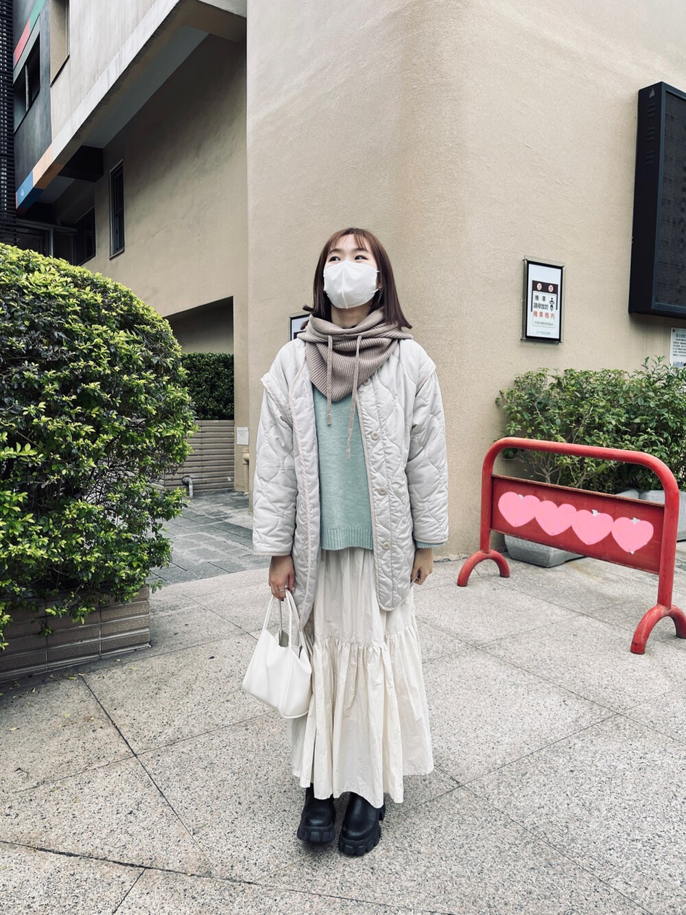 ホワイト系のスカート、ホワイト系のノーカラージャケットを着用したレディースの冬コーディネートの2枚目の写真