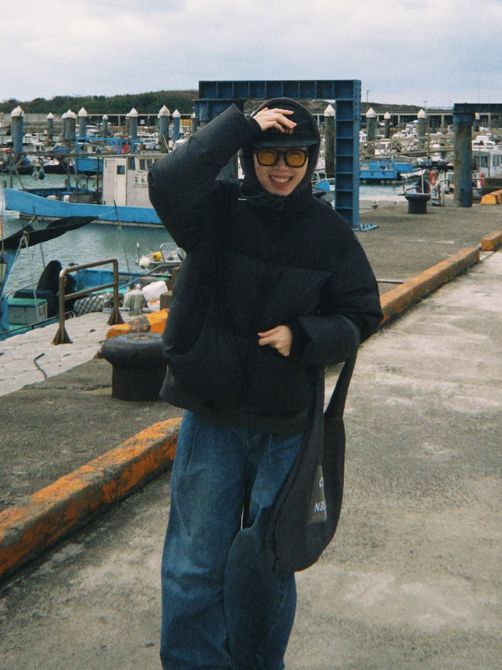 グレー系のトートバッグ、ブラック系のキャップを着用したレディースの春コーディネートの2枚目の写真