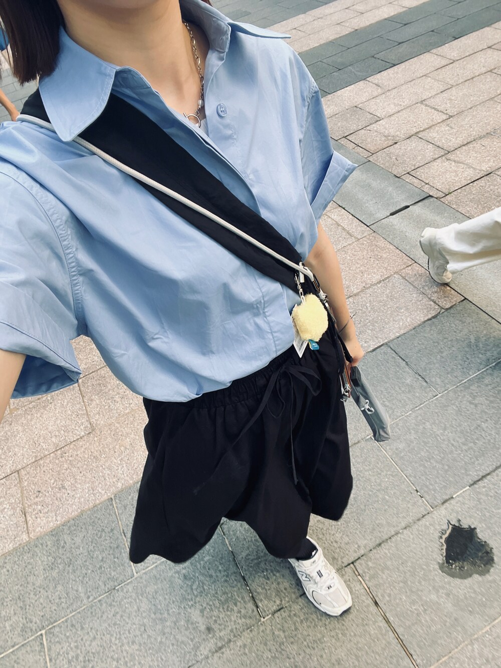 ブルー系のシャツ/ブラウス、ブラック系のスカートを着用したレディースの夏コーディネートの2枚目の写真