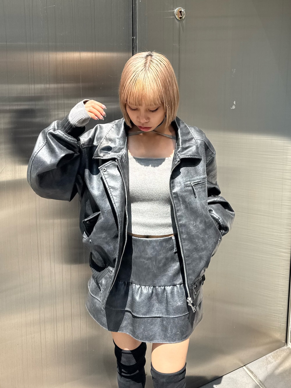 グレー系のブルゾン、グレー系のスカート、グレー系のニット/セーターを着用したレディースの秋コーディネートの4枚目の写真